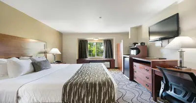 a hotel room with a bed and a flat screen tv at SureStay Plus Hotel by Best Western Rocklin in Rocklin