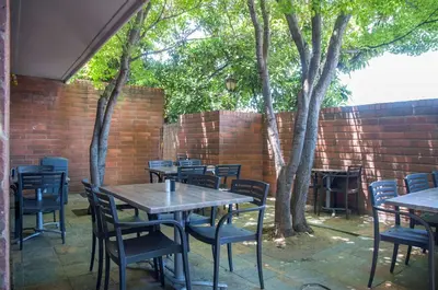 an outdoor patio with tables and chairs and trees at Best Western Village Inn in Fresno