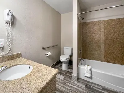 a bathroom with a sink and a toilet and a shower at Rodeo Lodge in Clovis