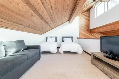 a living room with a couch and a tv at Snowflower 12 in Mammoth Lakes