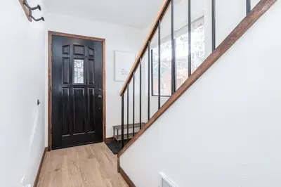 a hallway with a black door and stairs at Snowflower 12 in Mammoth Lakes