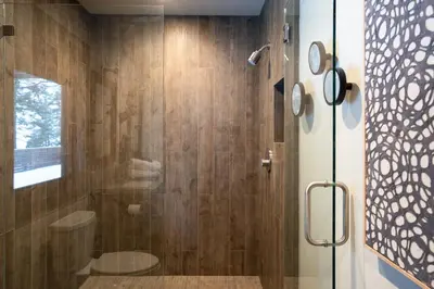 a bathroom with a shower with a glass door at West Shore - West Shore Hideaway in Tahoma