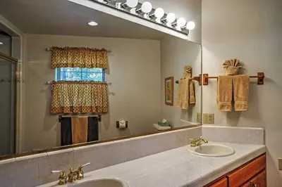 a bathroom with a sink and a large mirror at Hot Tub, Deck and Trail Access Shaver Lake Cabin in Shaver Lake