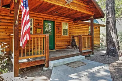 a log cabin with an american flag on the porch at Hot Tub, Deck and Trail Access Shaver Lake Cabin in Shaver Lake