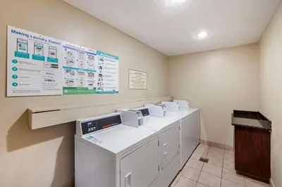 a row of washers and dryers in a laundry room at Best Western Plus Orchid Hotel & Suites in Roseville