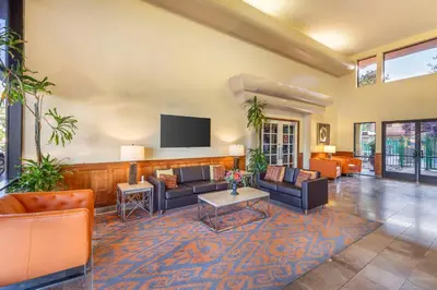 a living room with couches and a flat screen tv at Best Western Plus Orchid Hotel & Suites in Roseville