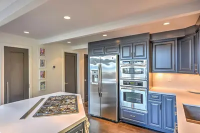 a kitchen with blue cabinets and a stainless steel refrigerator at 10 Mi to Skiing Tahoe City A-Frame Home in Tahoe City