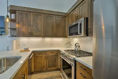 a kitchen with wooden cabinets and a stove top oven at Walk to Ski Shuttle Truckee Condo with Hot Tub in Truckee