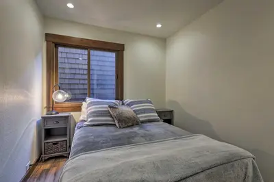 a bedroom with a large bed with a window at Walk to Ski Shuttle Truckee Condo with Hot Tub in Truckee