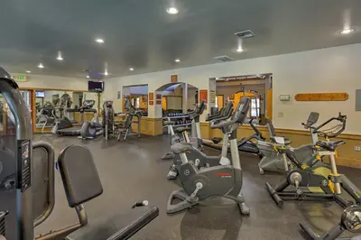 a gym with several treadmills and exercise bikes at Walk to Ski Shuttle Truckee Condo with Hot Tub in Truckee