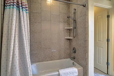 a bathroom with a tub and a shower with a shower curtain at Casa dAmore Extravagant Lakefront Villa! in Granite Bay