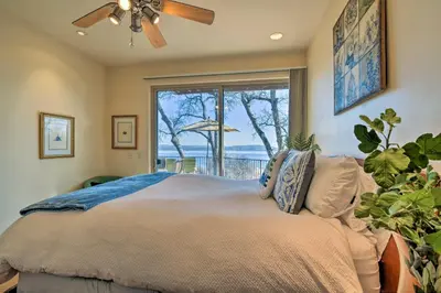 a bedroom with a bed with a ceiling fan and a window at Casa dAmore Extravagant Lakefront Villa! in Granite Bay