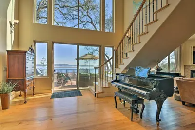 a living room with a piano and a staircase at Casa dAmore Extravagant Lakefront Villa! in Granite Bay