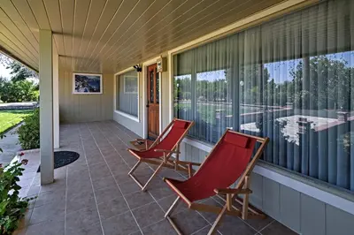 two red chairs on the porch of a house at 7 Mi to Dtwn Gilroy Spacious Home on 20 Acres! in Gilroy