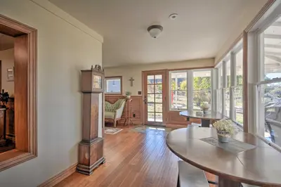 a living room with a table and some windows at Historic Mariposa Stagecoach Stop with Gas Fire Pit! in Mariposa