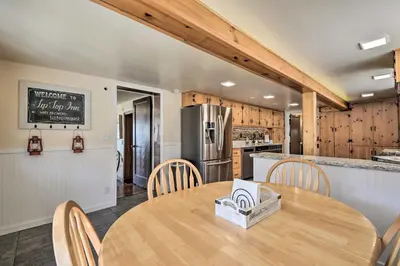 a kitchen and dining room with a wooden table and chairs at Historic Mariposa Stagecoach Stop with Gas Fire Pit! in Mariposa