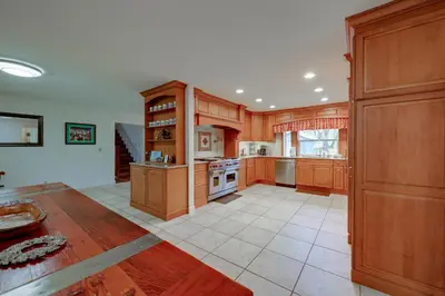 a large kitchen with wooden cabinets and a stove at 7 Mi to Bass Lake! Spacious Mudge Ranch Retreat in Coarsegold