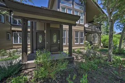 a house with a front porch with a door and trees at Mammoth Lakes Vacation Rental with Community Hot Tub in Mammoth Lakes