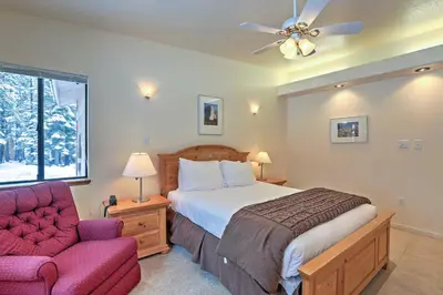 a bedroom with a bed and a chair and a ceiling fan at Rustic Truckee Lodge with Rec Room - Near Northstar! in Truckee