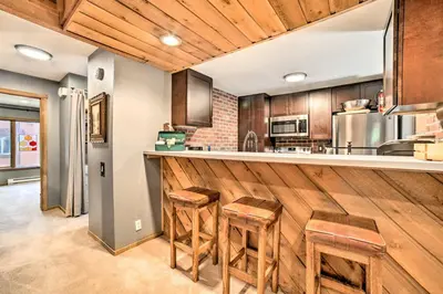 a kitchen with a bar with stools in it at Renovated Mammoth Lakes Retreat with Private Balcony in Mammoth Lakes