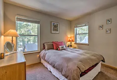 a bedroom with a bed and two windows at Cabin Less Than 2 Mi to Tahoe Donner Downhill Ski Resort in Truckee