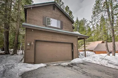 a brown house with a garage in the snow at Cabin Less Than 2 Mi to Tahoe Donner Downhill Ski Resort in Truckee