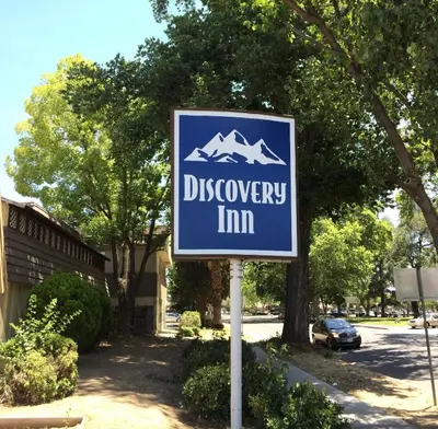 a sign for a discovery inn on a street at Discovery Inn in Modesto