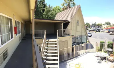 a building with stairs in front of a building at Discovery Inn in Modesto