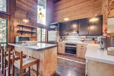 a large kitchen with wooden walls and wooden floors at Free Ski Shuttle! Spacious Northstar Resort Cabin in Truckee