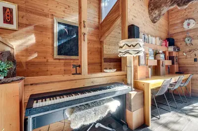 a room with a piano and a table in it at Free Ski Shuttle! Spacious Northstar Resort Cabin in Truckee