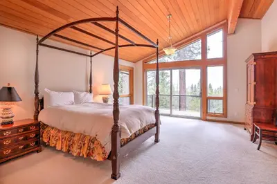 a bedroom with a canopy bed and a large window at Mtn and Lake Views Incline Village Ski Chalet in Incline Village