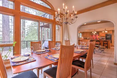 a dining room with a table and chairs and a kitchen at Mtn and Lake Views Incline Village Ski Chalet in Incline Village