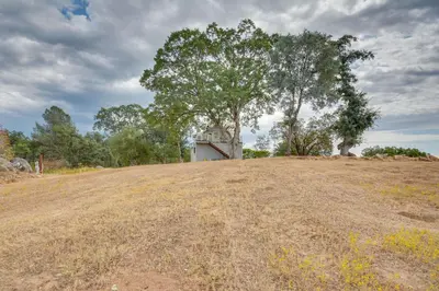 a house on top of a hill with a tree at Mariposa Home Furnished Patio and Sierra Mtn Views in Mariposa