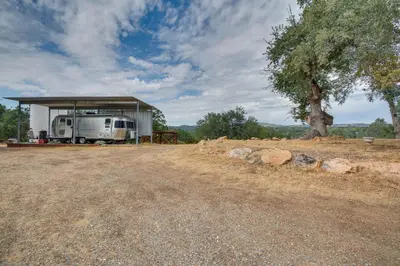 an rv parked under a shed with a tree at Mariposa Home Furnished Patio and Sierra Mtn Views in Mariposa