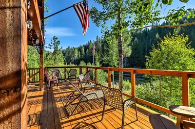 a deck with chairs and tables and an american flag at Rustic Riverfront Truckee Cabin with Deck and BBQ in Truckee