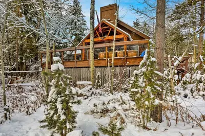 a log cabin in the woods in the snow at Rustic Riverfront Truckee Cabin with Deck and BBQ in Truckee