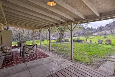 an outdoor patio with a table and chairs on a deck at Cozy Home with Patio Near Yosemite National Park! in Mariposa