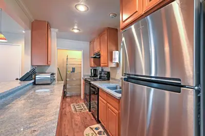 a kitchen with a stainless steel refrigerator and wooden cabinets at Remodeled and Cozy Gilroy Guest House Near Downtown! in Gilroy
