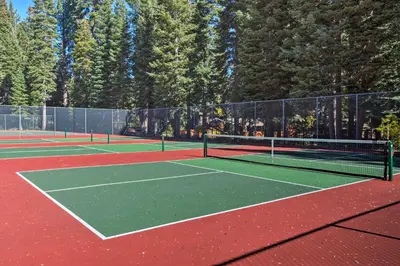 a couple of tennis courts with trees in the background at 11 Mi to Palisades Tahoe Lakefront Home with View! in Tahoe City