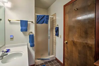 a bathroom with a sink and a shower with blue towels at 11 Mi to Palisades Tahoe Lakefront Home with View! in Tahoe City
