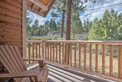 a porch with a rocking chair on a cabin at Mammoth Lakes Townhome - 10-Min Walk to Village! in Mammoth Lakes