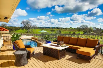 a patio with a couch and chairs on a deck at Working Vineyard and Private Pool Villa in Plymouth in Plymouth