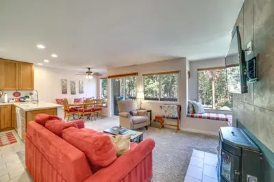 a living room with a red couch and a kitchen at Quiet Condo with Great Views, half Mi to Eagle Lodge! in Mammoth Lakes