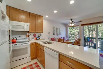 a kitchen with wooden cabinets and white appliances at Quiet Condo with Great Views, half Mi to Eagle Lodge! in Mammoth Lakes
