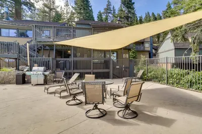 a patio with chairs and a table with a yellow canopy at Quiet Condo with Great Views, half Mi to Eagle Lodge! in Mammoth Lakes