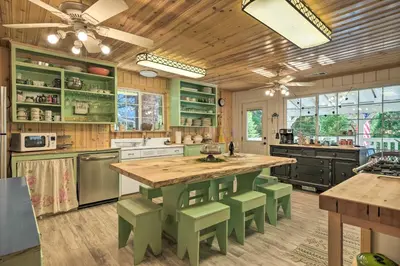 a kitchen with a large wooden table and green stools at Strawberry Hill Cabin 5 Mi to Skiing and Lake in Strawberry