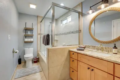 a bathroom with a tub and a sink and a mirror at Family Home with Pool about 7 Mi to Downtown Sacramento! in Sacramento