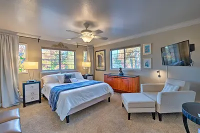 a bedroom with a bed and a tv and a chair at Luxurious Downtown Lodi Apartment in Wine Country! in Lodi