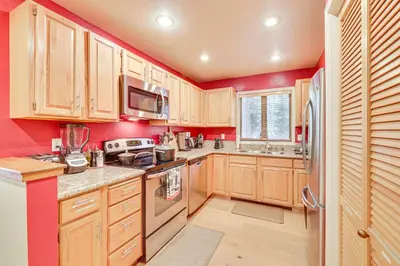 a kitchen with red walls and wooden cabinets at 2 Mi to Diamond Peak! Corner-Unit Condo with Hot Tub in Incline Village
