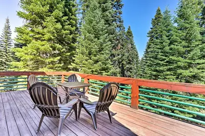 two chairs and a table on a deck with trees at Forest Views and Beach Access Family Truckee Gem in Truckee